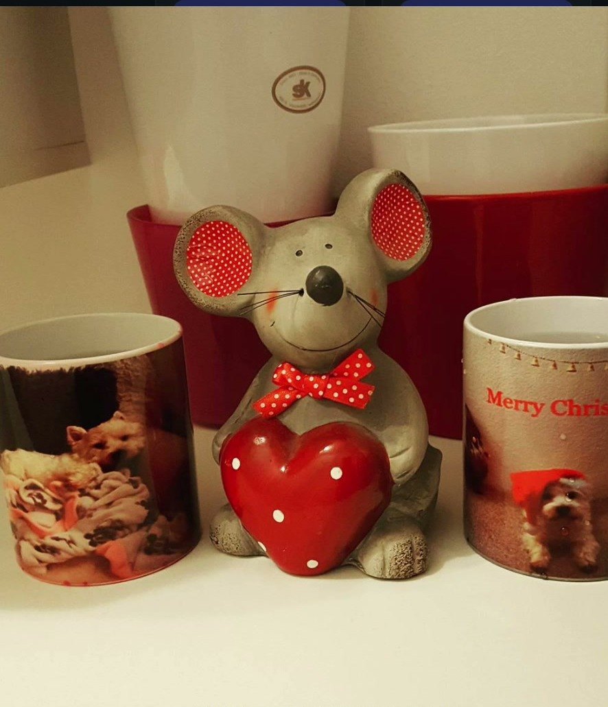 Drei Tassen mit aufgedruckten Fotos, dazwischen eine Deko-Maus