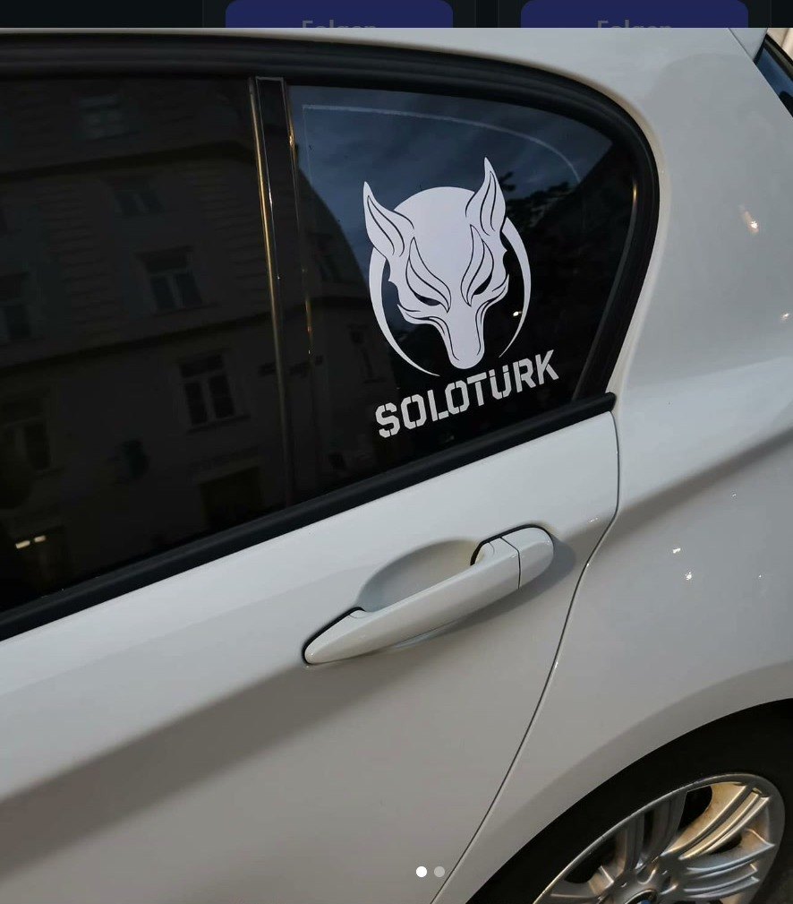 Weißes Auto mit weißem Sticker auf der hinteren Seitenscheibe